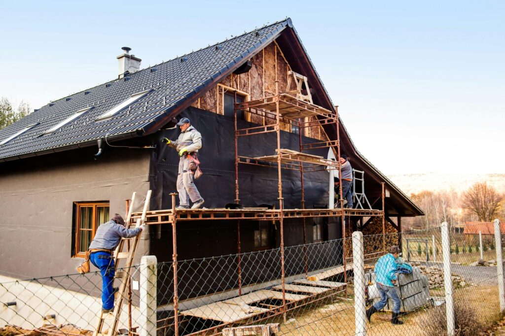 Práce na fasádě rodinného domu s využitím lešení